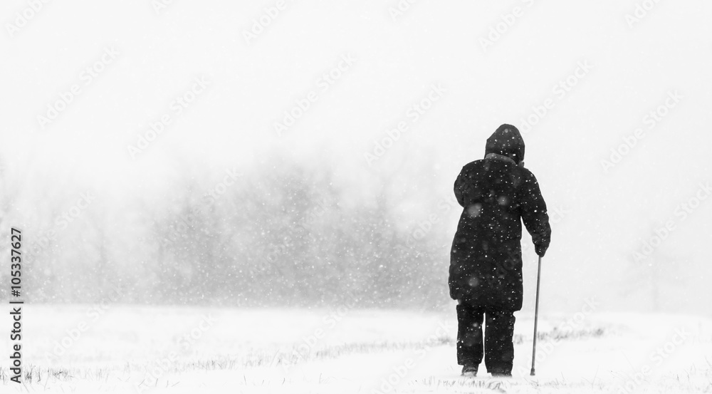 Old woman in snow blizzard