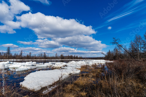 Spring day landscape with river, debacle and cloudy sky 