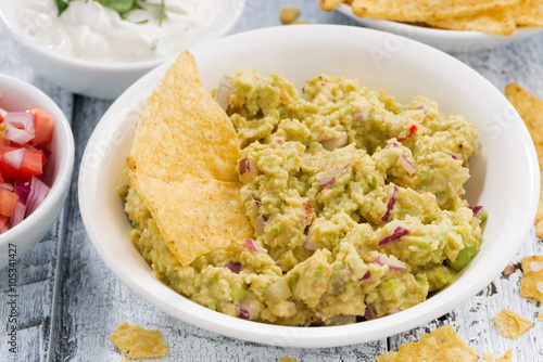 spicy avocado sauce and assorted sauces with corn chips, closeup