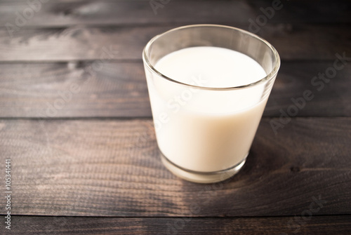 Glass of milk on wooden background