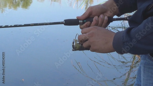 Angler fishing spinning reel on the rod