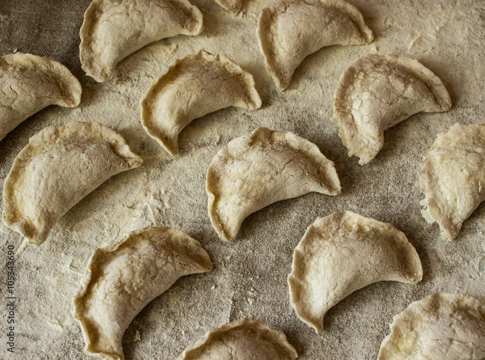 Homemade dumplings, uncooked, only molded on a linen tablecloth. Homemade dumplings, uncooked, only molded on a linen tablecloth.