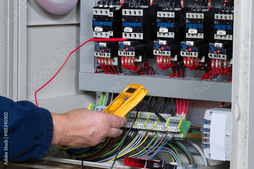 electrician at work with an electric panel photo