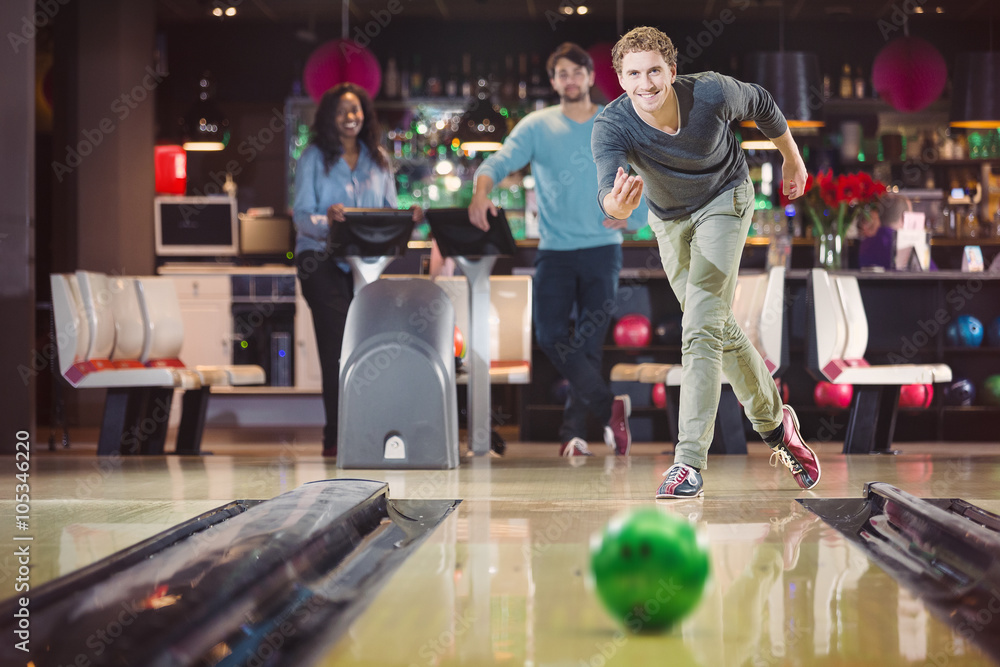 Plakat Uśmiechnięty szczęśliwy mężczyzna rzuca bowlingball