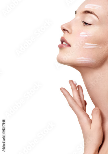 Beautiful Young Woman applying facial moisturizing cream.Skincar