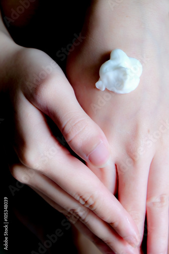 Wallpaper Mural female hands applying hand cream with black and with dark color Torontodigital.ca