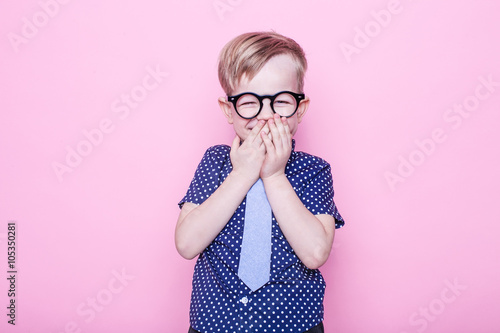 Little adorable kid in tie and glasses. School. Preschool. Fashion. Studio portrait over pink background photo
