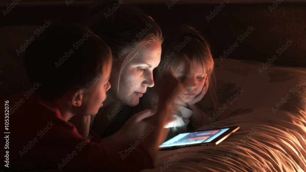 Mother and two children looking at tablet Mother and two children looking at tablet