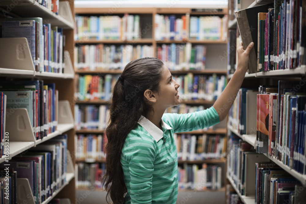 A girl looking at books in a library, A girl looking at books in a library,