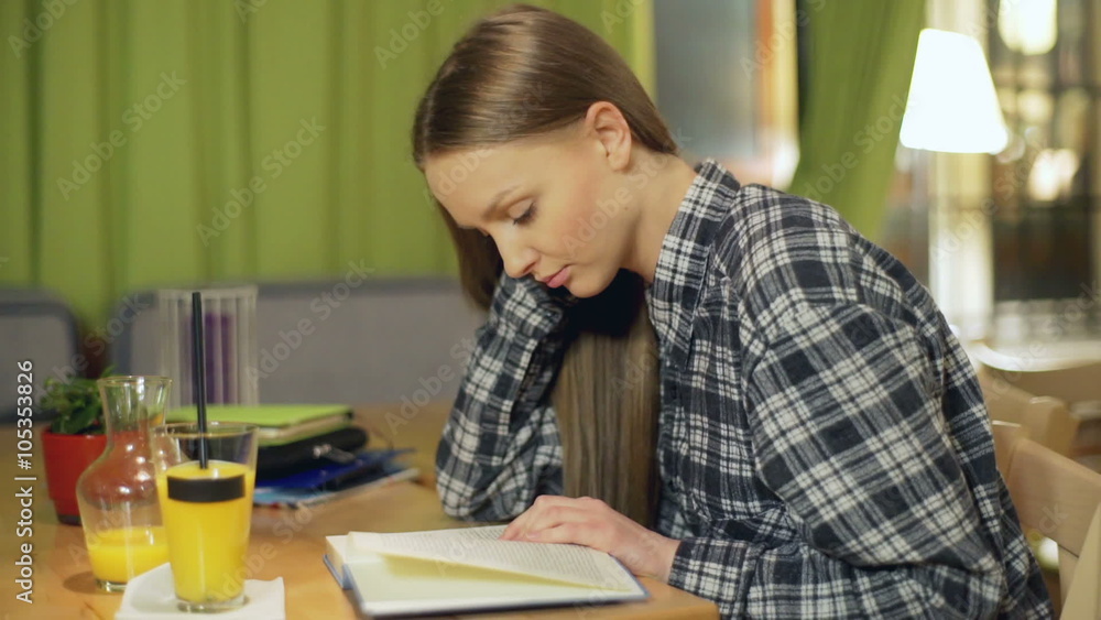 Girl reading book and smiling to the camera in the cafe, steadycam shot
Girl reading book and smiling to the camera in the cafe, steadycam shot