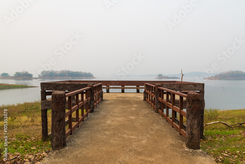 Wooden balcony on the lake that covering by morning fog.