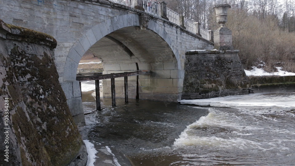 Water flowing underneath the old bridge. Melting ice, foam, antic stonework. Panning. Water flowing underneath the old bridge. Melting ice, foam, antic stonework. Panning.