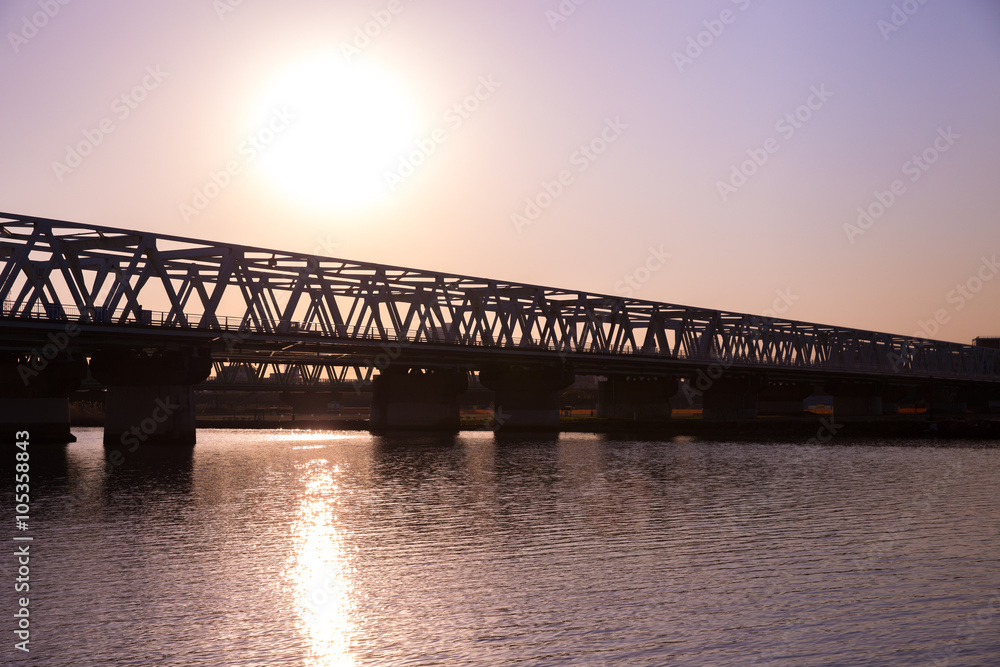 夕暮れ時の鉄橋と電車