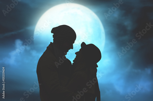 Silhouettes of a couple with starry and lunar background. 