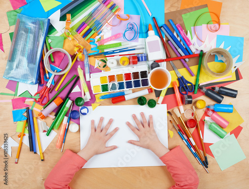 Child drawing top view. Artwork workplace with creative accessories. Flat lay art tools for painting.