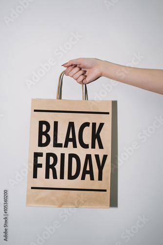 kraft bag with the inscription in the hands of Black Friday
