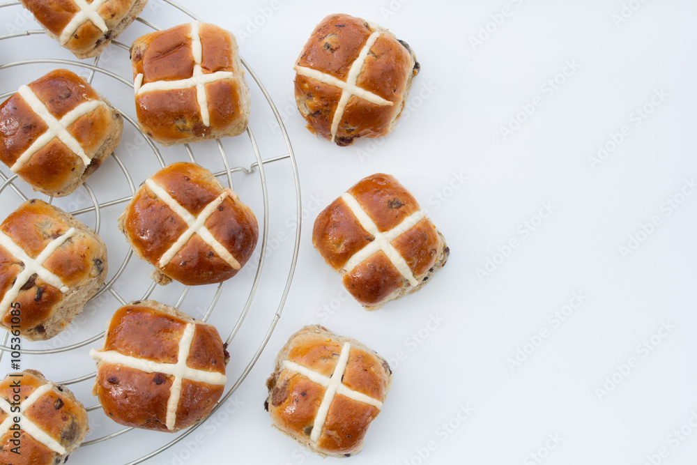 Fototapeta premium Freshly baked, Easter hot cross buns on an isolated white background.