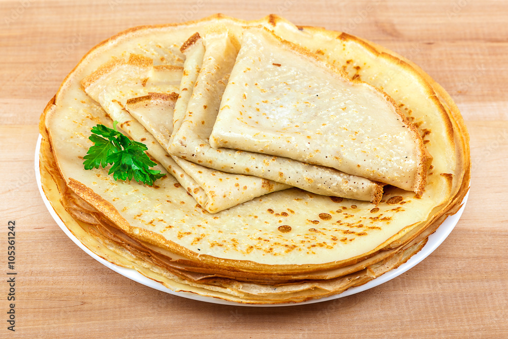 Pancakes in the plate on a wooden background Pancakes in the plate on a wooden background