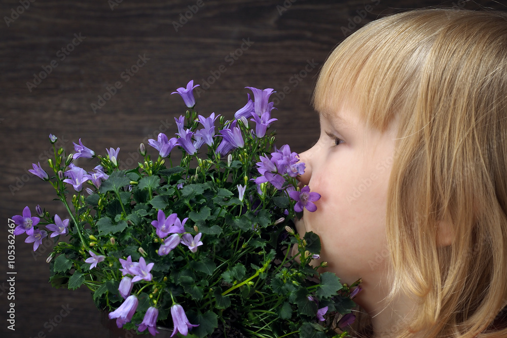 Naklejka premium Little girl with a bouquet of wild flowers - wild bells