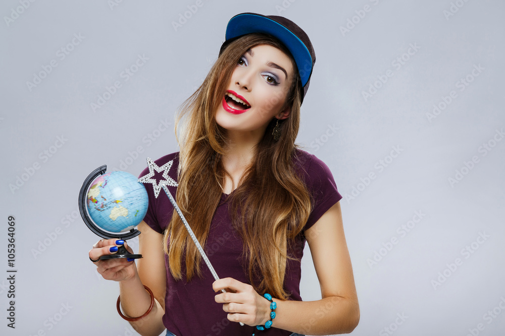 Fototapeta premium Young girl with little globe at gray background