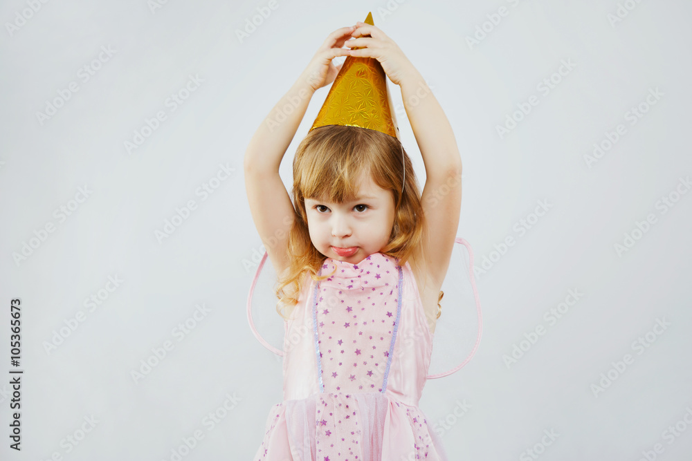Funny girl touching tip of her hat in studio