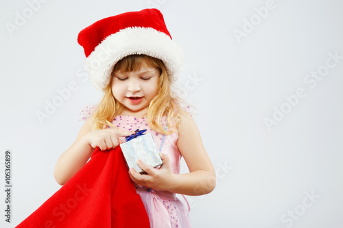 Little girl holding red bag for presents in studio