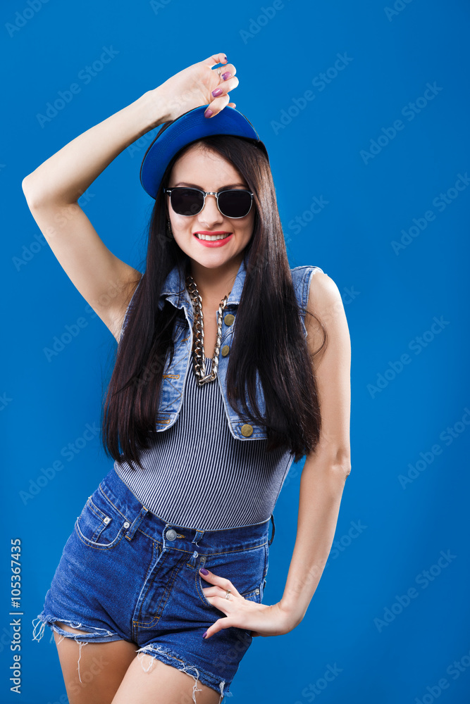 Young smiling woman posing on blue background, in studio Young smiling woman posing on blue background, in studio