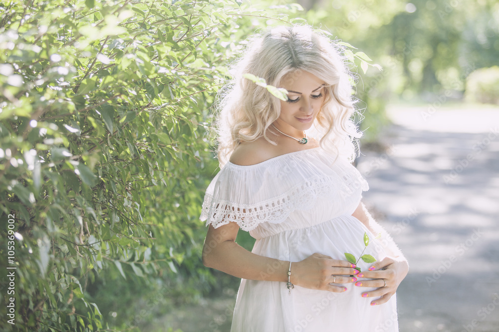 Young beautiful pregnant woman in the Park, summer day in the su Young beautiful pregnant woman in the Park, summer day in the su