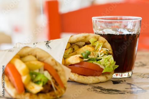 Greek cuisine, souvlaki, gyro pita. and a glass of drink. In the tavern in Greece