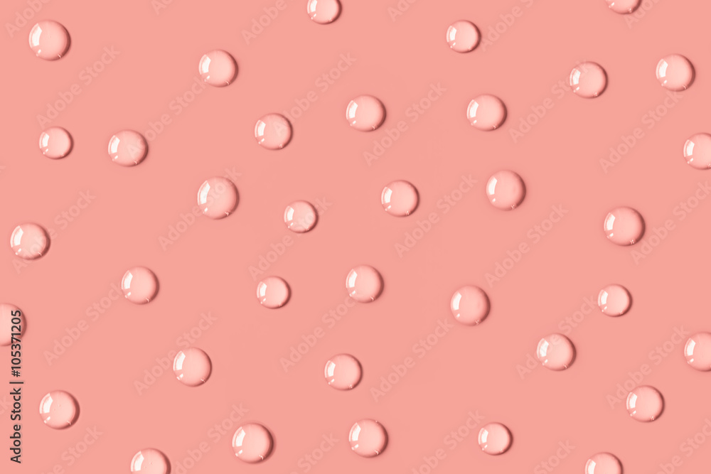 The pink drops of water on the table. The salmon color. Background. The pink drops of water on the table. The salmon color. Background.