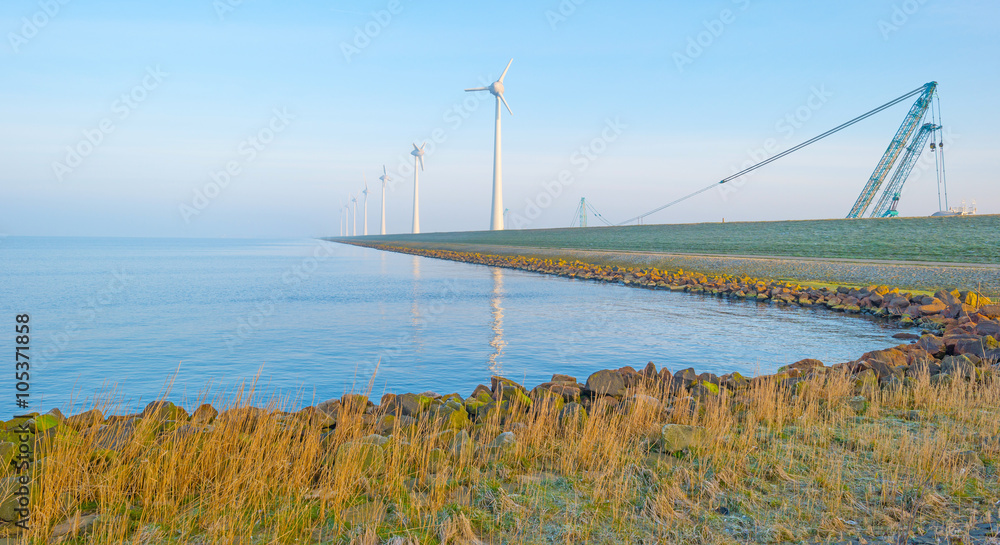 Wind turbine under construction along a dike Wind turbine under construction along a dike