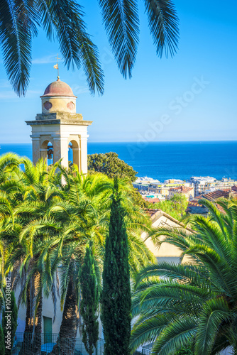 Tableau sur toile the belfry and church's roof is hiding behind the palms, sanremo, italy