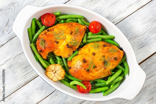 baked chicken breasts with green beans and tomatoes, top view