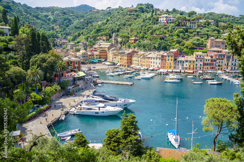 Pier and boats on bockground of colorful houses in bay of Portofino, Italy. photo