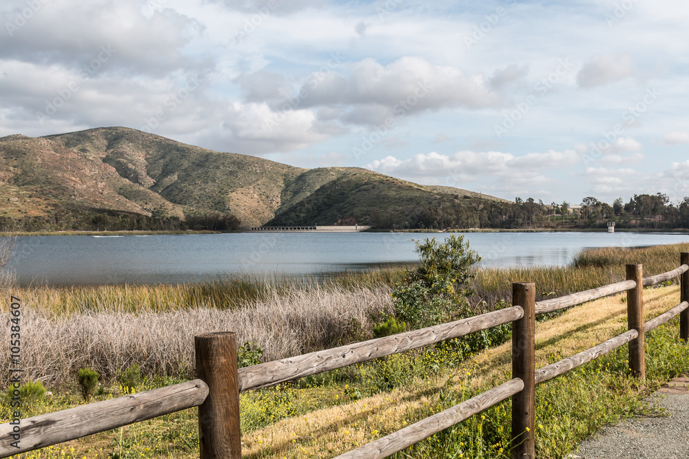 Mountain range, lake and fence in foreground Otay Lakes County Park in Chula Vista, California.
