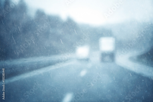 Abstract blurred traffic dangerous highway driving in heavy rainfall. Stormy conditions on the highway. Blur effect visualizies poor vision and dynamics at rainy weather.