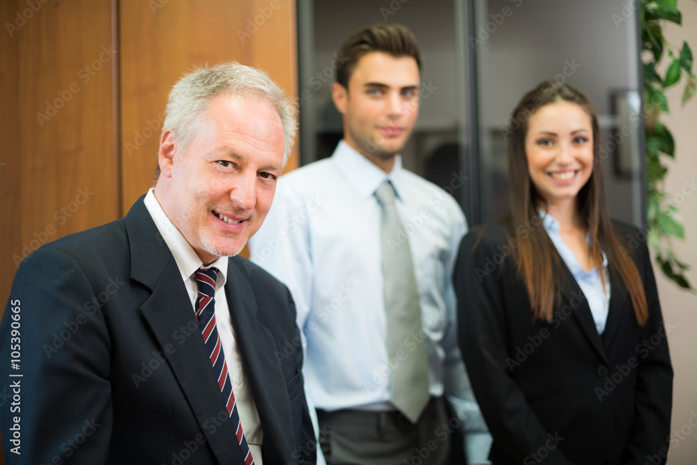 Smiling businessman in front of his colleagues