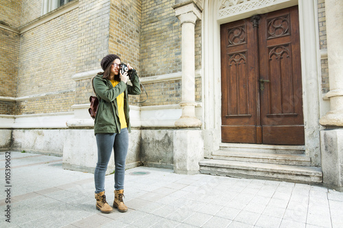 Moder young woman takeing a pictures on a vacation. She is takeing a pictures of the architecture.