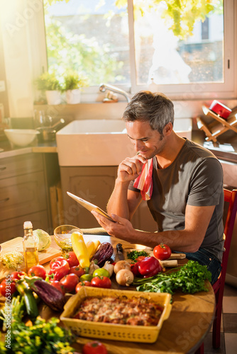 Grey haired man looking at vegetables recipes on a tablet