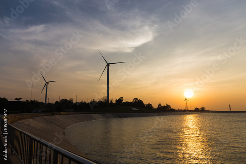 power generator wind turbines at sunset with reservoir © powerbeephoto