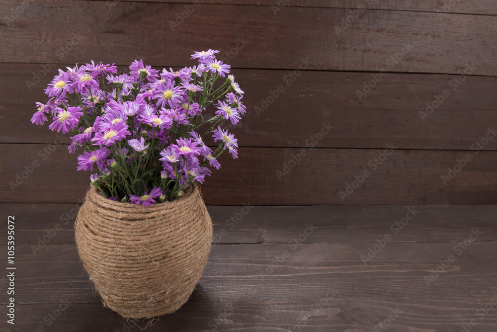 Purple cutter flowers in the jar, on the wooden background Purple cutter flowers in the jar, on the wooden background