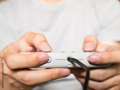 A young man holding game controller playing video games