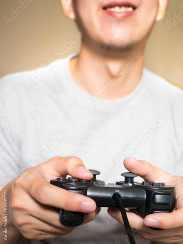 A young man holding game controller playing video games (vintage tone)