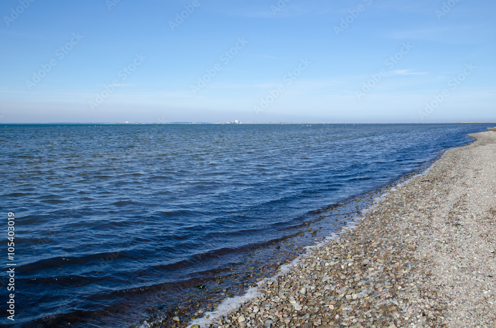 Shoreline with blue water and pebbles Shoreline with blue water and pebbles