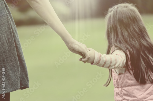 Mother holding a hand of her daughter in summer day outdoors vin © phaitoon