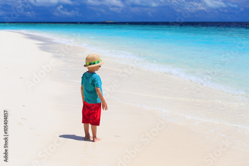 little boy looking at tropical beach photo