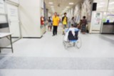 Blurred people and patient in the hospital background 