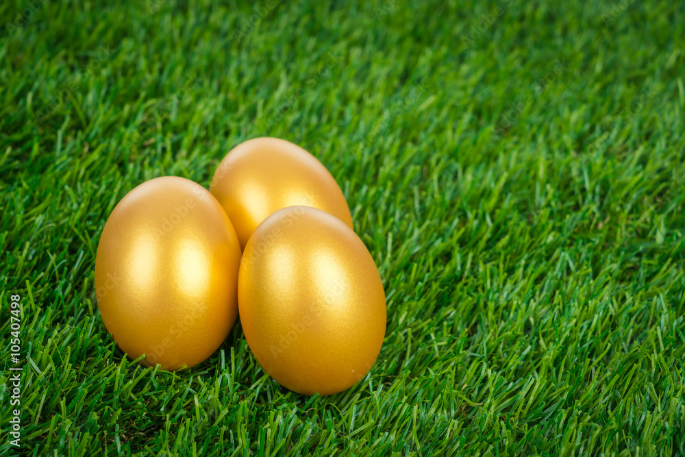 Gold easter egg on a green grass Gold easter egg on a green grass