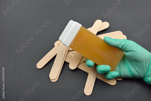 Beauticians hand with green glove holding a roll on liposoluble photo