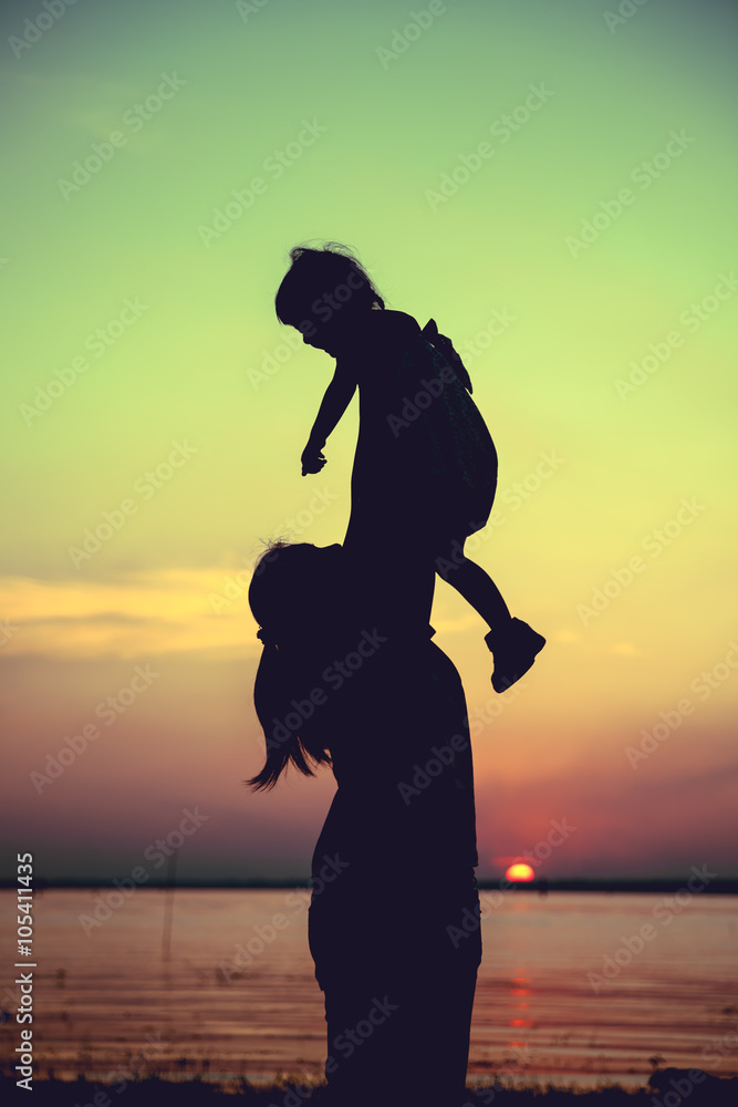 Silhouette of mother and child enjoying the view at riverside.